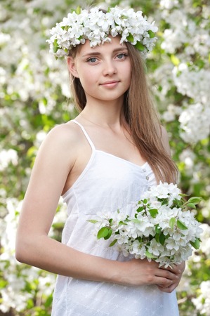 Portrait of a young girl in blossoming apple treesの写真素材