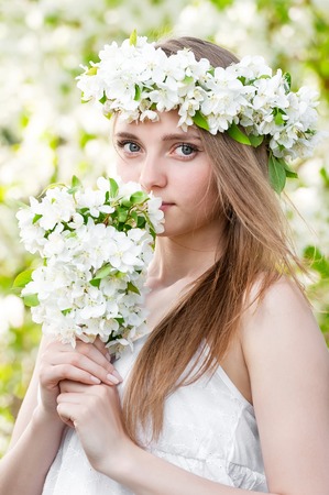 Portrait of a young girl in blossoming apple treesの写真素材