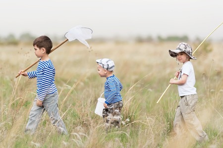 Three boys - fishermen on a meadow at the catchの写真素材