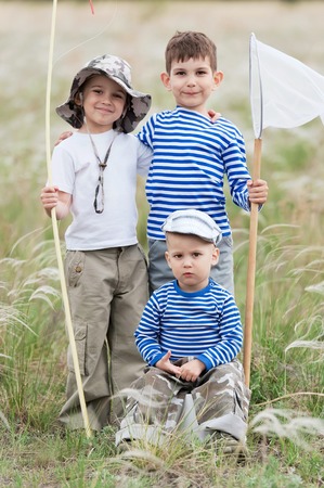 Three boys - fishermen on a meadow at the catchの写真素材