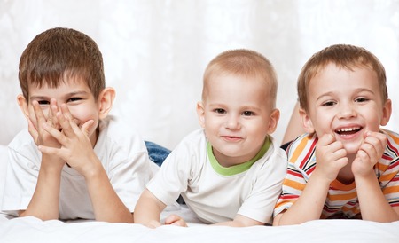 Portrait of happy young boys on the bedの写真素材