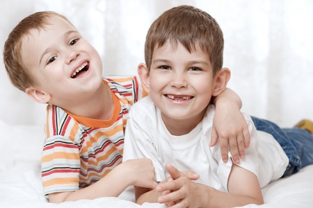 Portrait of happy young boys on the bedの写真素材
