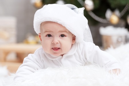 Little boy on a bed under the Christmas treeの写真素材