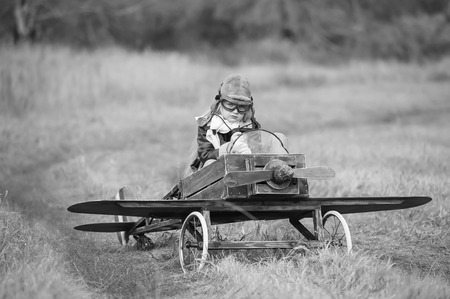 Young female pilot in a homemade plane in a field on a sunny autumn dayの写真素材