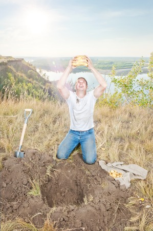 Young man on the edge digs gold hot summer dayの写真素材