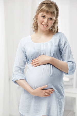 Portrait of a young pregnant woman in the interiorの写真素材