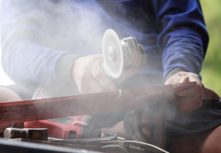 carpenter sawing wood with electric sawの写真素材