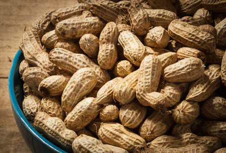groundnut in blue bowl on wood background