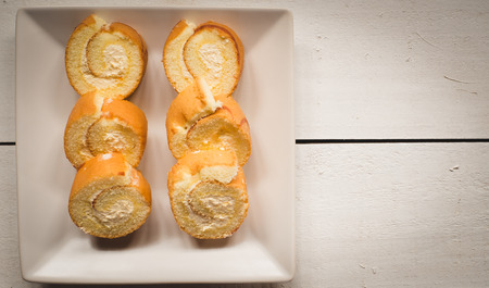 slice roll cake on white woodの写真素材