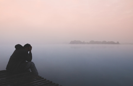 alone man sitting with sadness emotion on wood pierの写真素材