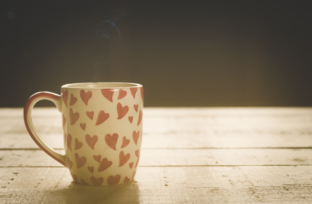 red heart cup coffee on white wood in morningの写真素材