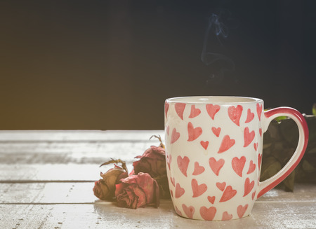 red heart cup coffee on white wood in morningの写真素材