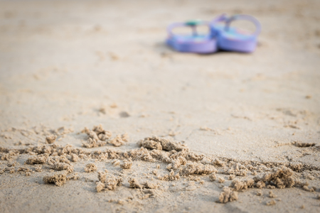 purple flipflop on sand beachの写真素材