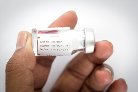 hand holding bottle with label expiration of medicine