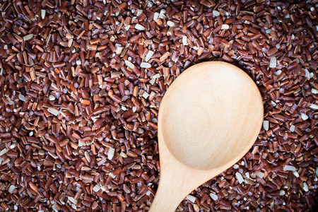red rice with wooden spoonの写真素材