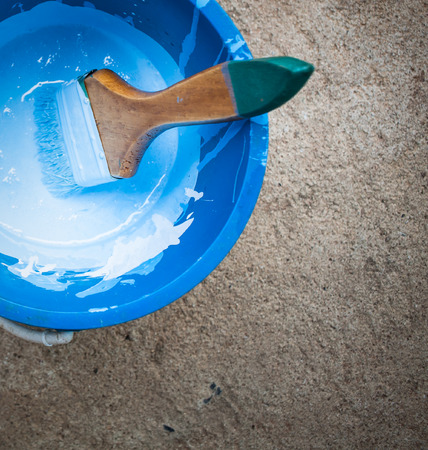 painting tool with color in bucket on floorの写真素材