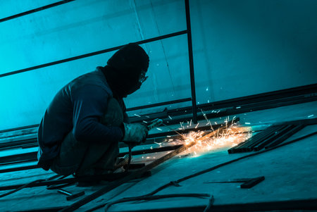 worker making sparks  from welding steel in dark room