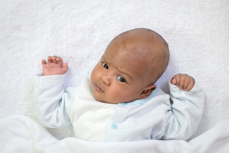 newborn asian boy baby sleeping on white furry clothの写真素材