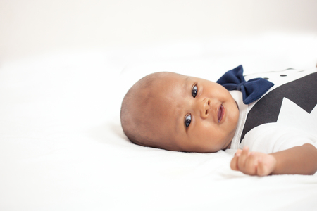 newborn asian boy baby sleeping on white furry clothの写真素材