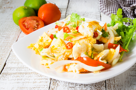 spicy salad with fried eggs. yum kai dao in thai name. thai cuisine on white woodの写真素材