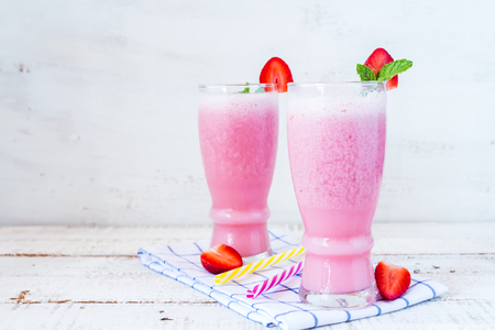 healthy fresh strawberry smoothie on white wooden boardの写真素材