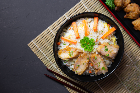 Fried rice with korean style chicken on black table. Top view.の写真素材