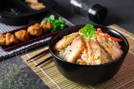 Fried rice with korean style chicken on black table. Top view.の写真素材