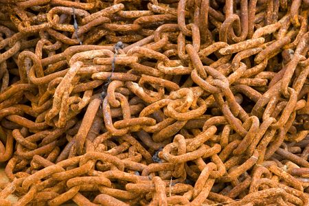 A pile of rusty chains encrusted with salt lying on the beachの写真素材