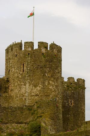 Two of the round towers of Conwy Castle, Wales with the Welsh flag flyingの写真素材