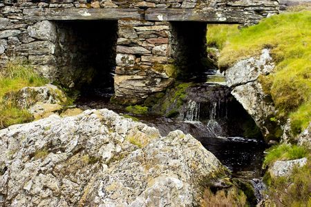 waterfall under a typical slate bridge in the welsh high moorlandの写真素材