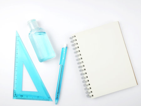 note book and hand sanitizer on white background.