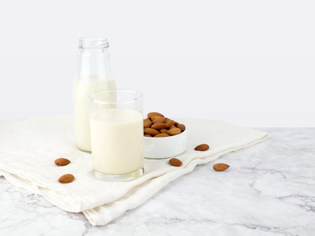 Almonds with milk on marble texture background.