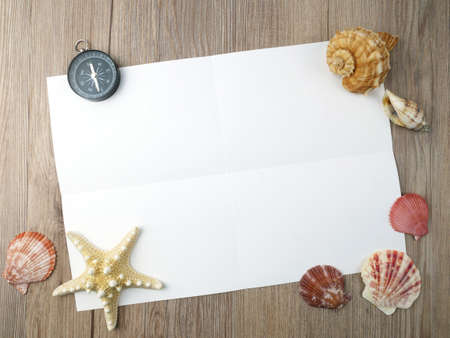 Sea shells and paper on wooden backgroundの写真素材