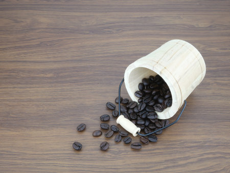 Coffee beans in bucket on wooden texture background.