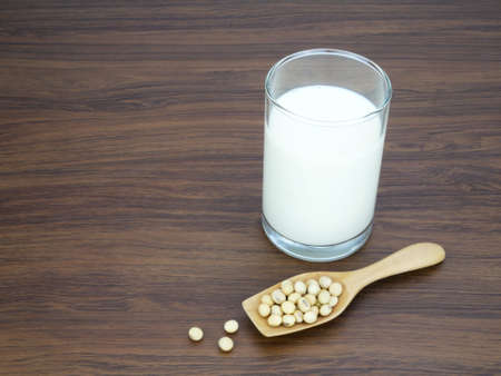 Soy milk in glass and spoon on wooden texture background.の写真素材