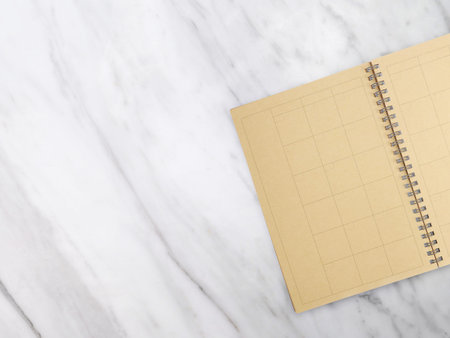 Notebook with pencil on marble texture background