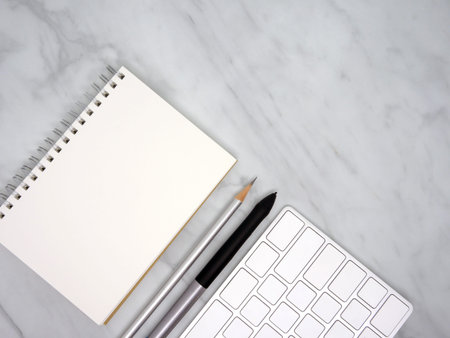 Notebook with keyboard on marble texture background