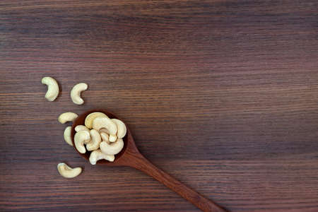 Roasted cashew nut in bucket on wooden texture backgroundの写真素材
