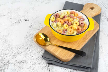 Corn flakes and milk in bowl on tableの写真素材