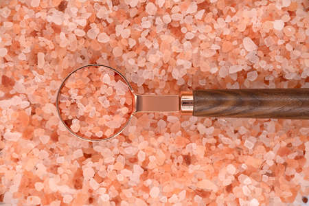 Himalayan pink salt in a spoon on himalayan pink salt texture backgroundの写真素材
