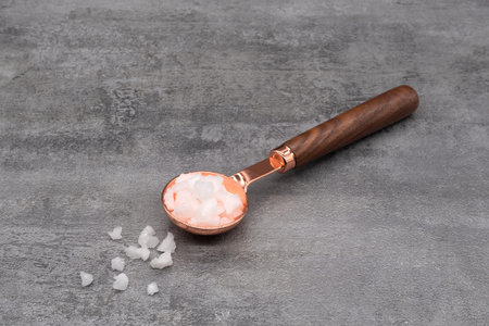 Sea salt in a spoon on stone texture backgroundの写真素材