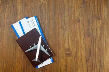 Passport with boarding pass on wooden texture background. Tourism and travel concept. Top view. Flat lay.の写真素材