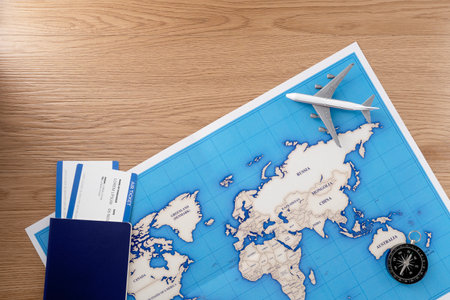 Passport with map on wooden texture background. Travel concept background. Flat lay.の写真素材