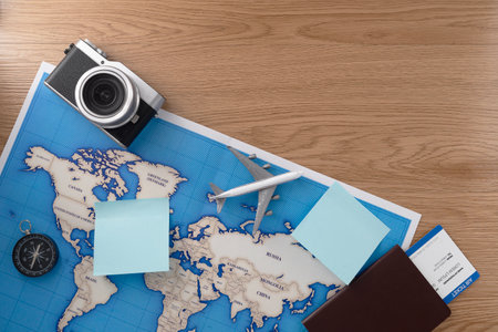 Passport with map and camera on wooden texture background. Travel concept background. Flat lay.の写真素材