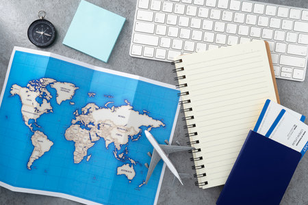 Passport with map and keyboard and notebook on wooden texture background. Travel concept background. Flat lay.の写真素材