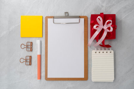 Gift box with clipboard on stone texture background. Planning. Flat lay. Top view.の写真素材