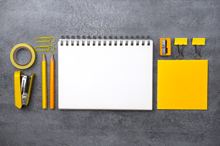 Notebook and yellow stationery on stone texture background. Work desk spaceの写真素材