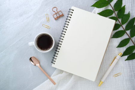Notebook and leaf on stone texture background. Work desk space