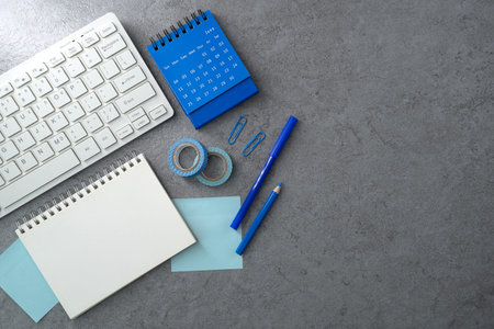 Keyboard and notebook on stone texture background. Work desk space