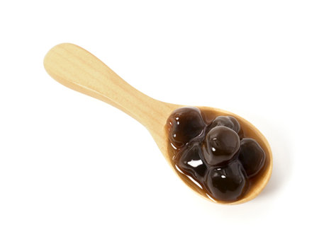 Brown sugar pearls bubble in wooden spoon isolated on white backgroundの写真素材